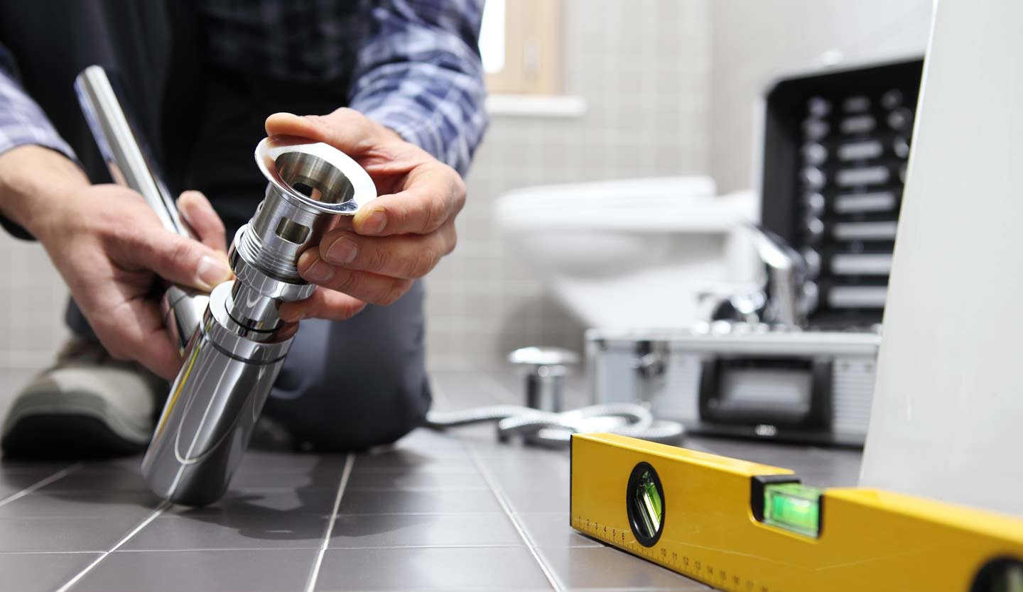 Plumber fitting a chrome sink trap during a plumbing repair during well pump repair in Wake Forest, NC